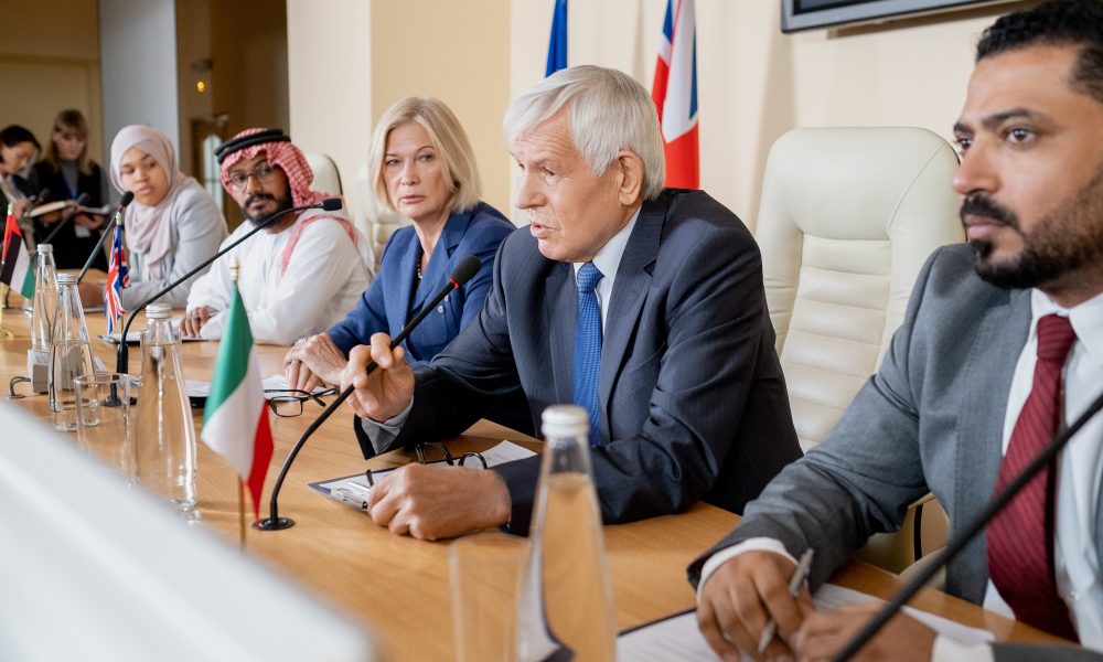 Aged politician in formalwear making report for audience at conference