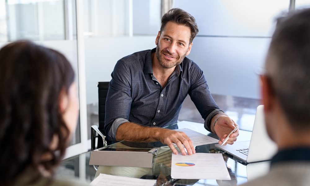 Confident businessman advising couple on finance