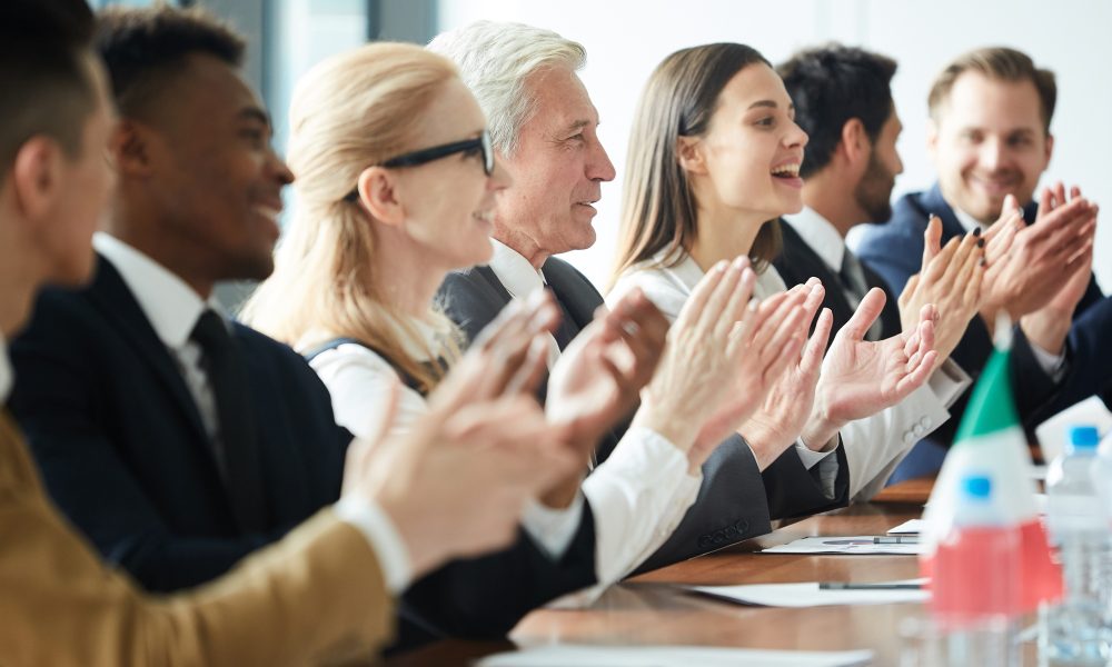 Excited government representatives applauding after meeting