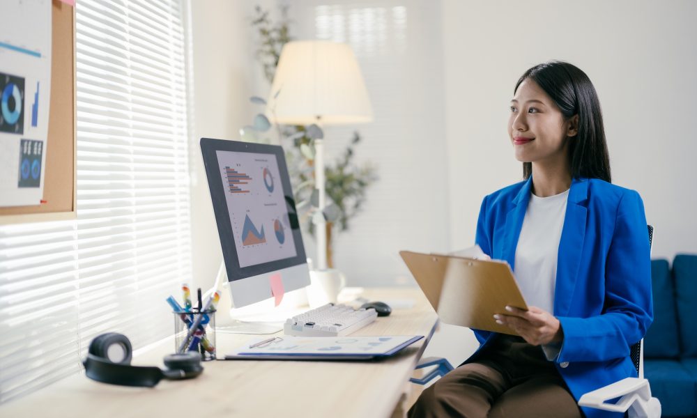 Focused young asian businesswoman in modern office, contemplating career path with confidence and de