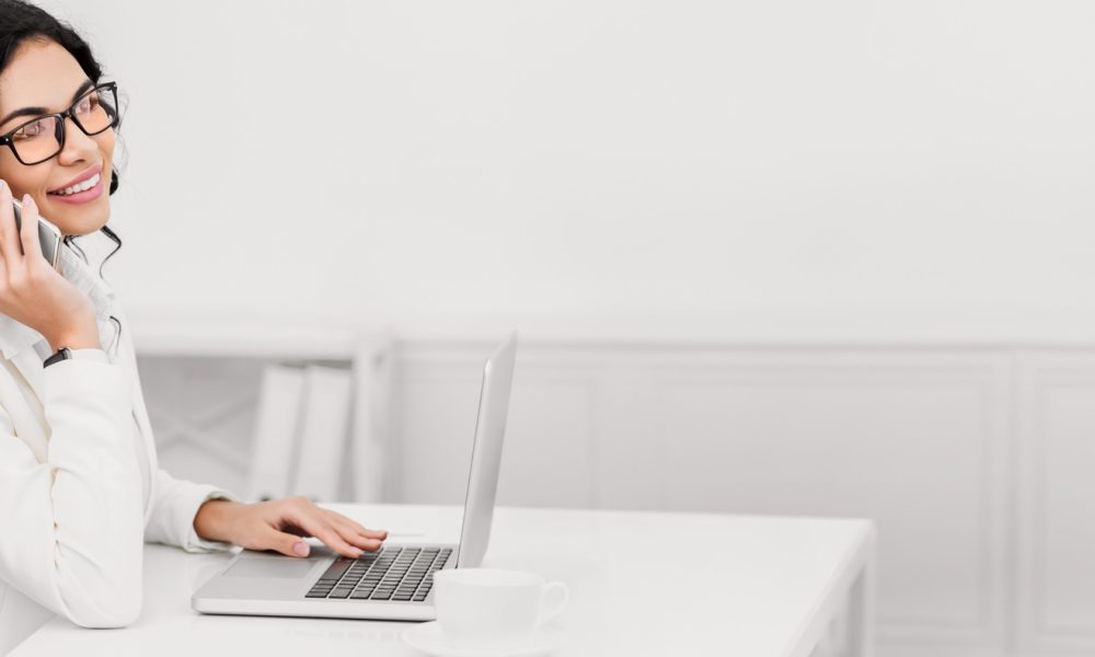 Latin girl talking on phone working at office