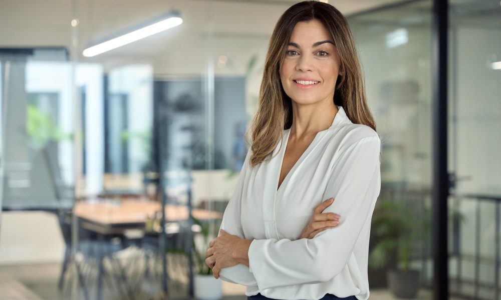Smiling confident Latin professional mature business woman in office, portrait.